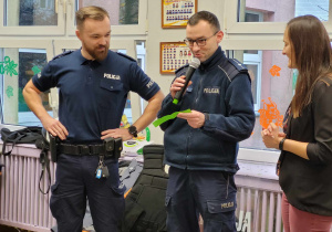 Pan policjant czyta wcześniej przygotowaną zagadkę na którą odpowiedz znają przedszkolaki.