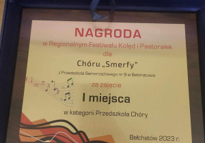 Grafika przedstawiająca nagrodę otrzymaną przez grupę „Smerfy”.