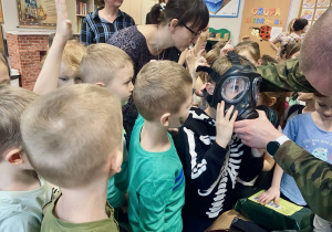 Chłopiec przymierza maskę przeciwgazową.