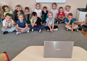 Na zdjęciu dzieci oglądają film edukacyjny „Grzybobranie”.