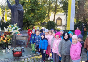 Zdjęcie dzieci z grupy Pszczółki przy pomniku Jana Pawła II.