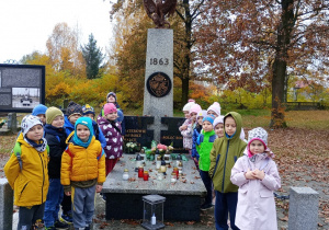 7.Przedszkolaki stojący obok grobu żołnierzy walczących w powstaniu w 1863 roku.