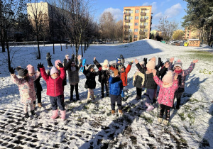 Dzieci pozują na tle zimowego krajobrazu.