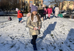 Dzieci bawią się na górce w pobliżu przedszkola.