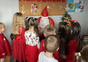 Grupa „Liski” wręcza słodki upominek Mikołajowi.