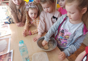 Dziewczynka ugniata ciasto, z którego będzie wypiekane pieczywo.