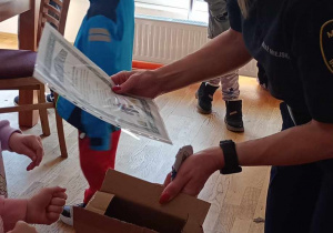 Strażniczka Miejska otrzymująca podziękowanie od dzieci za przeprowadzone zajęcia.