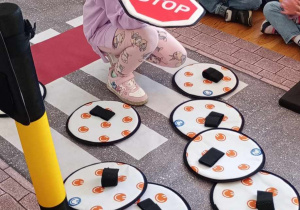Dziewczynka spośród znaków wskazuje znak stop.