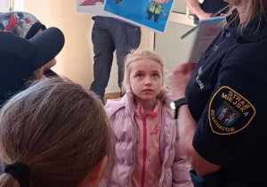 Strażniczka miejska wręcz dzieciom dyplom za udział w zajęciach.