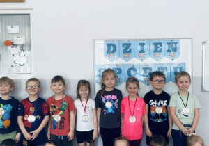 Cała grupa pozuje do zdjęcia z otrzymanymi medalami.