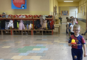 Chłopiec maszeruje utrzymując piłeczkę na paletce.