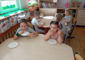 Dzieci z grupy Odkrywcy zjadają słodkie czekoladowe przysmaki.
