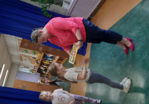 Dziewczynka z grupy „Pszczółki” odbiera nagrodę za zajęcie I miejsca.