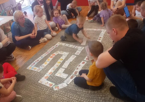 Dzieci bawią się wspólnie z rodzicami w świąteczne domino.