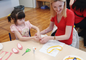 Dziewczynka z mamą podczas pracy nad koszyczkiem wielkanocnym.