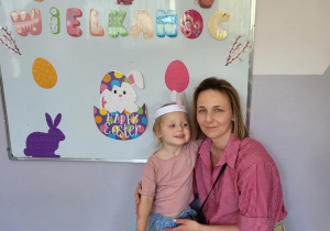 Dziewczynka z mamą pozują do zdjęcia.