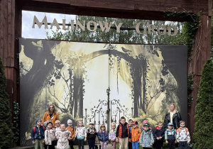 Grupa Motylki pozuje do zdjęcia na wycieczce pod bramą „Malinowego Grodu”.