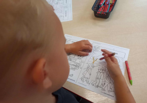 Chłopiec z grupy „Misie”, koloruje obrazek o dobrym zachowaniu.