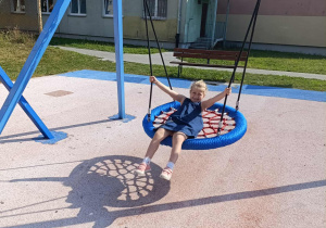 Dziewczynka huśta się na huśtawce.