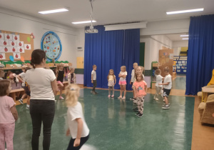 Zdjęcie przedstawia dzieci ustawione w kole.