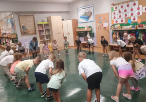 Zdjęcie rpzedstawia dzieci wykonujące ćwiczenia gimnastyczne.