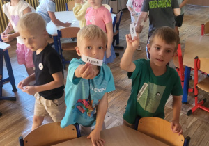 Trzech chłopców trzyma kartonik ze swoim imieniem.