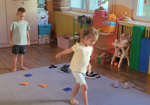 Dziewczynka pokonuje tor przeszkód – chodzi boso po woreczkach.