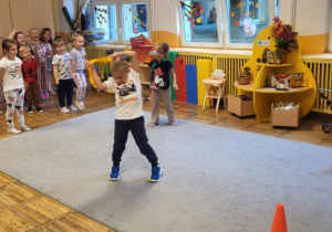 Dzieci przechodzą przez szarfę.