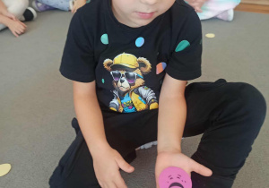 Chłopiec z grupy „Misie” pokazuje kropkę ze smutną buzią