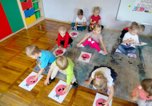 Dzieci z grupy Słoneczka podczas układania kropek na rysunku biedronki.