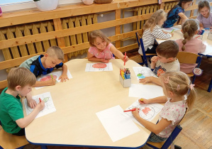 Na zdjęciu widzimy dzieci z grupy Odkrywcy podczas wykonywania pracy plastycznej z okazji Dnia Jabłka.