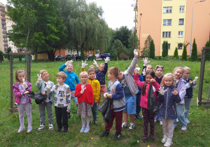 Dzieci pozują do zdjęcia w rękawiczkach i z workami.