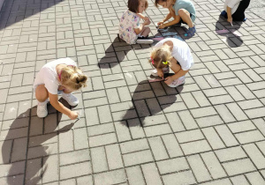 Dzieci malują kredą.