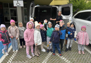 Dzieci pozują przy radiowozie Straży Miejskiej.