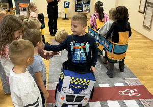 Dzieci oglądają radiowóz Straży Miejskiej.