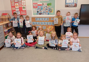 Dzieci z grupy Odkrywcy pozują z pracą plastyczną wykonaną z okazji Dnia Chłopaka.