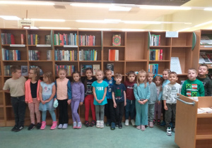 Dzieci pozują do zdjęcia na tle jednego z wielkich regałów.