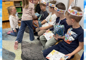 Dziewczynka wręcza prezent z okazji Dnia Chłopaka koledze z grupy