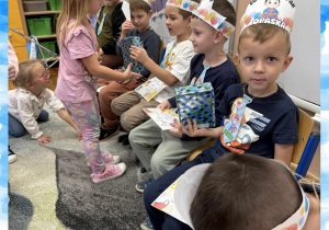 Dziewczynka wręcza prezent z okazji Dnia Chłopaka koledze z grupy