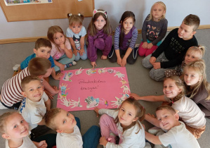 Dzieci z grupy Odkrywcy prezentują plakat pt. „Przedszkolna drużyna” podczas realizacji zajęć o budowaniu relacji w grupie.