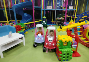 Dzieci jadą samochodzikami.