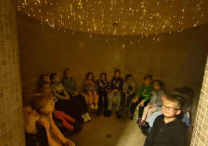 Dzieci siedzą w kręgu i relaksują się.