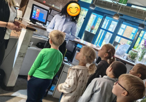 Dzieci z grupy Motylki stoją przy recepcji w hotelu.