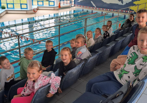 Dzieci z grupy Motylki zwiedzają basen w hotelu, siedzą na trybunach.
