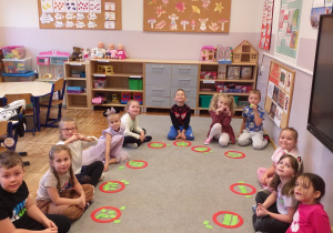 Zdjęcie przedstawia dzieci rozwiązujące zadania matematyczne z książkami.