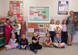 Zdjęcie przedstawia dzieci pozujące do wspólnej pamiątkowej fotografii ze swoimi paniami.