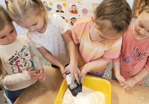 Dziewczynka wsypuje do miski sól.