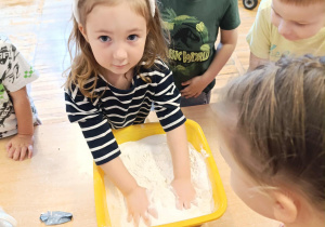 Dziewczynka miesza składniki w misce.