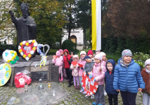 Dzieci z grupy Odkrywcy pozują do zdjęcia przy pomniku papieża Jana Pawła II.