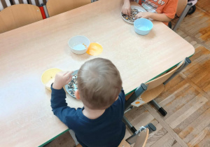 Chłopcy ćwiczą motorykę małą.